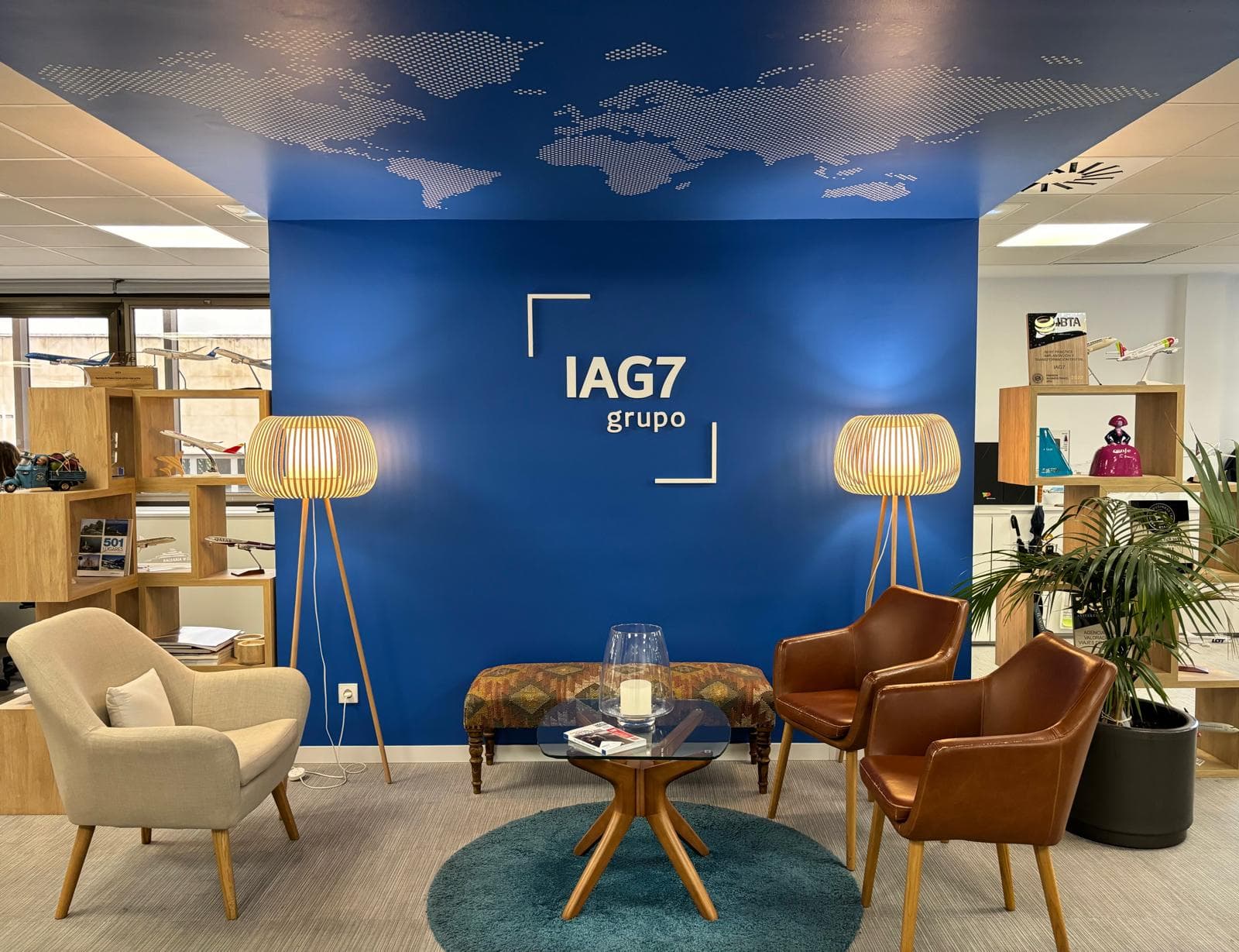 Recepción de Grupo IAG7 con el logotipo IAG7 grupo en pared azul y zona de espera.