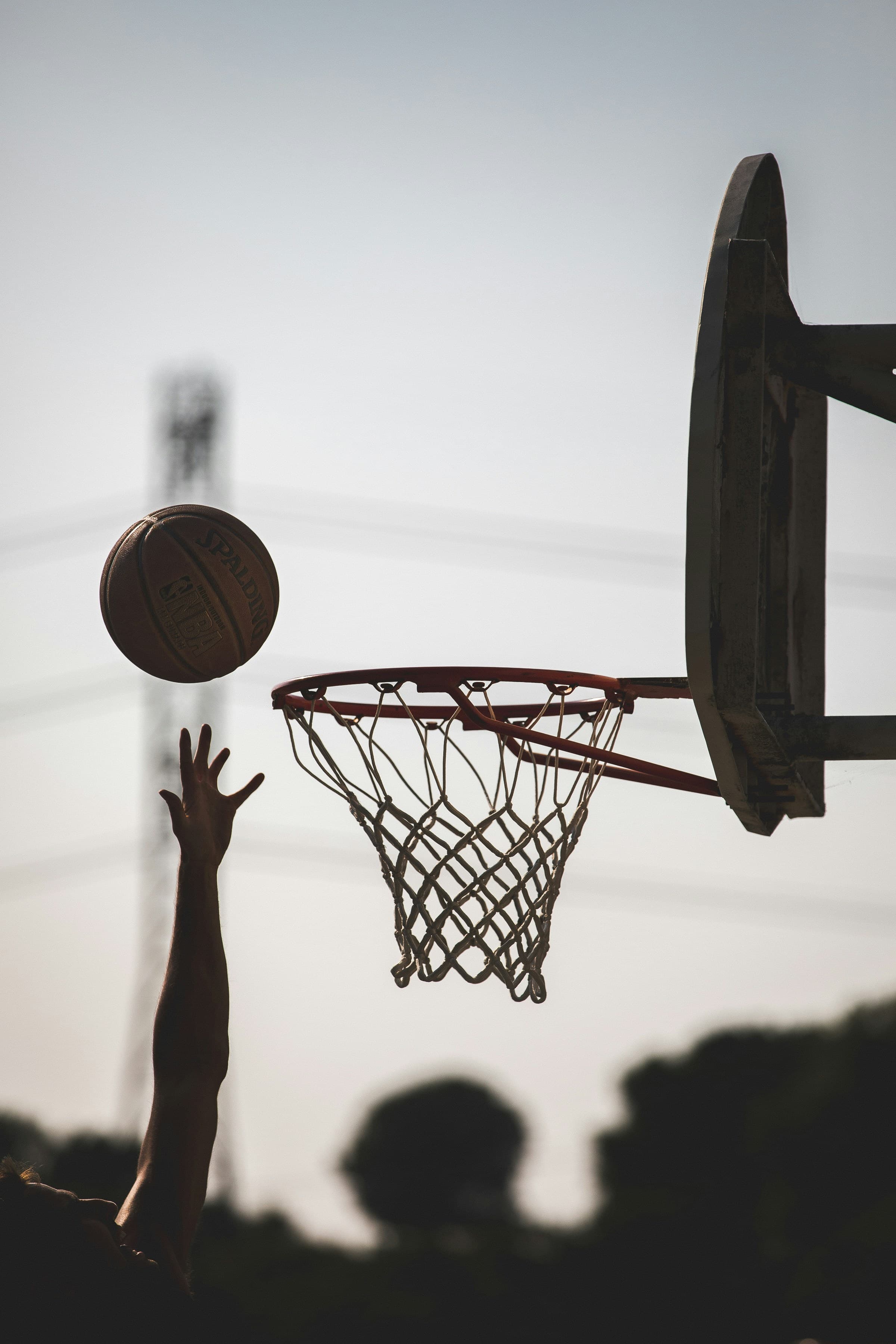 Balón de baloncesto en el aire junto a la canasta, deporte en pista exterior.